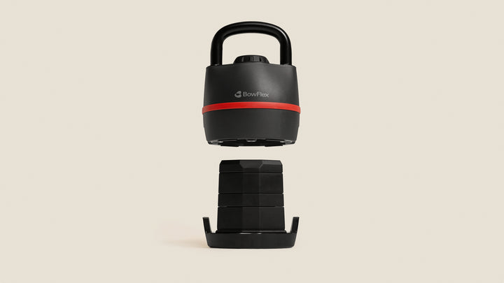 The BowFlex SelectTech 840 Kettlebell lifted above its weight plates.