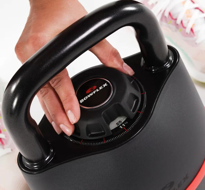 Hand adjusting the selection dial on the BowFlex SelectTech 840 Kettlebell.