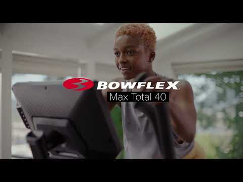 Close up front view of a person exercising the BowFlex Max Total 40 while looking at its console.